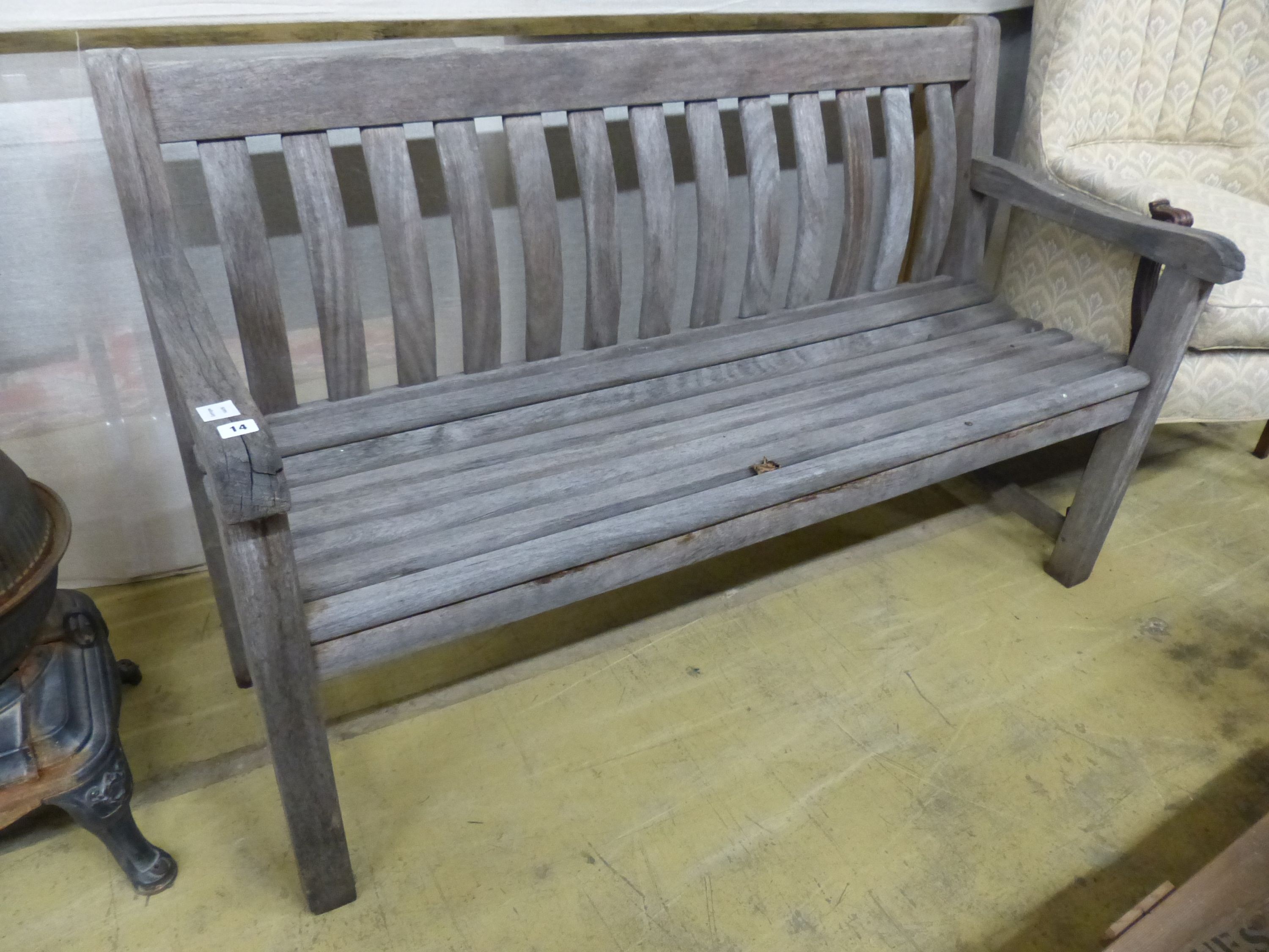 A weathered teak garden bench. W 150 cms.